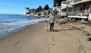 Mr. Deets walking on the beach with dog