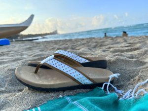 Sandals and towel in the sand at the beach