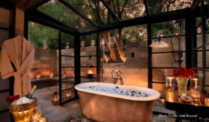 Outdoor Bathtub filled with bubbles and rose petals with candles surrounding the tub.
